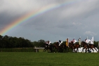 Pferderennen mit Regenbogen im Hintergrund